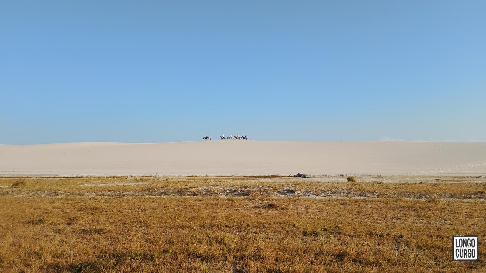 Avistamos grupo cavalgando sobre as dunas no horizonte